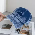Dettaglio del cappello da baseball in denim blu lavato con strappi ed eleganti ricami - Regolabile / Blu scuro
