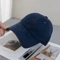 Detailopname van het rode HO HO HO borduursel op de marineblauwe katoenen honkbalpet - Verstelbaar / Marineblauw