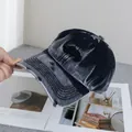Dettaglio del berretto da baseball vintage lavato con ricamo e fori consumati sulla visiera - Regolabile / Nero