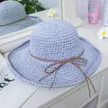Detailed close-up of light purple woven straw hat with brown string bow on a vanity - M(56-58cm) / Blue