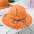 Detail of a bright orange woven straw hat with a slim brown leather bow decoration - M(56-58cm) / Orange