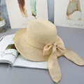 Overhead view of beige straw sun hat with large bow on a stylish aesthetic background - Adjustable / Beige