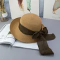 Close-up of wide brim straw sun hat with brown ribbon bow on a decorative magazine - Adjustable / Khaki