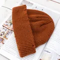 Detalle de gorro de punto color caramelo con diseño desgastado y textura de canalé en revista - Caramelo