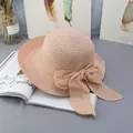 Dettaglio cappello di paglia rosa a tesa larga con fiocco grande e trama intrecciata - Regolabile / Rosa
