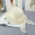 Dettaglio di un cappello di paglia intrecciato a mano con fiocco e trama traspirante - Regolabile / crema