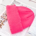 Primer plano de un gorro de punto acanalado rosa brillante con detalles desgastados en revista - Rosa Oscuro