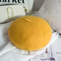 Dettaglio del basco in lana giallo zenzero con trama morbida e decorazione superiore - Taglia Unica Regolabile / Giallo zenzero