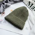 Detailansicht der dunkelgrünen Strickmütze mit grober Rippstruktur und weichem Wollstoff - Verstellbar / Grün