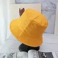 Detail of bright yellow cotton bucket hat with parallel brim stitching on a black stand - Ginger Yellow And Black