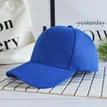 Dettaglio del berretto da baseball blu reale in cotone su un supporto bianco minimalista - Blu scuro