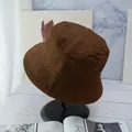 Detail view of brown cotton bucket hat with decorative stitching on the brim in studio - Coffee And Black