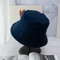 Close-up of navy blue cotton canvas bucket hat on a marble stand with magazine decor - Navy Blue And Black