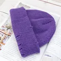 Dettaglio ravvicinato del berretto in maglia viola su uno sfondo di rivista - Stile di base / Viola