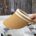 Detail of straw sun visor with striped ribbon on open magazine and wooden background - Adjustable / Khaki