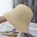Detailed close-up of the fine woven texture on this beige straw bucket sun hat - Adjustable / Beige