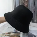 Detailed view of black woven straw bucket hat texture on minimalist wooden background - Adjustable / Black