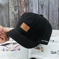 Détail d'une casquette noire à bord court avec écusson en cuir et broderie SBY - Réglable / Noir
