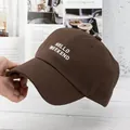 Close-up of HELLO WEEKEND embroidery on dark brown cotton baseball cap detail - Adjustable / Coffee