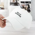 Detailed view of white canvas baseball cap with black HELLO WEEKEND embroidery texture - Adjustable / White