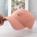 Close-up of pink baseball cap with black Teddy bear embroidery and cotton twill texture - Adjustable / Pink