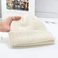 Detail of cream rib-knit beanie showing soft texture and wide fold-over cuff design - High Elasticity / Off White