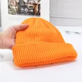 Dettaglio del berretto in maglia arancione con trama spessa e design a risvolto ampio - Alta elasticità / Arancione