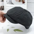 Detail of dark grey canvas newsboy cap showing eight-piece panels and neat stitching - Gray