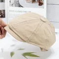 Detail of classic beige cotton newsboy cap showing textured fabric and stitching - Beige