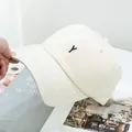 Détail d'une casquette en coton beige avec broderie Y noire et texture en sergé chic - Réglable / Poche zippée