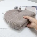 Primer plano de gorro de punto de piel de conejo marrón claro con textura de lana suave - Caqui