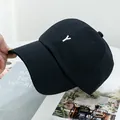 Détail d'une casquette en coton noir avec broderie blanche de la lettre Y à l'avant - Réglable / Noir