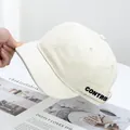 Dettaglio del cappello crema a tesa corta con ricamo laterale CONTROL nero intenso - Regolabile / Beige