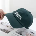 Close-up of white cursive 'Andyou' embroidery on dark green cotton canvas baseball cap - Adjustable / Dark Green