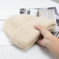 Textura detallada del gorro de punto grueso beige de pelo de conejo con borde doblado - Beige