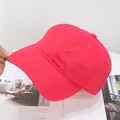 Detailed close-up of a premium red six-panel cotton baseball cap with curved brim and eyelets - Adjustable / Watermelon Pink