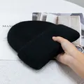 Primer plano del gorro de punto grueso de pelo de conejo negro con textura suave - Negro