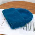 Primer plano detallado del gorro de punto azul oscuro con textura suave de mohair - Azul Pavo Real