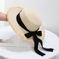 Detail van strooien hoed met gerafelde rand en een elegante zwarte strik - Verstelbaar / Beige Hoed Met Zwart Lint