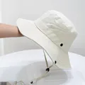 Close-up of beige wide brim bucket hat with reinforced stitching and windproof rope - Off-white