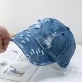 Detalle de gorra de béisbol en denim azul desgastado con agujeros vintage y bordes rústicos - Ajustable / Denim Azul Oscuro