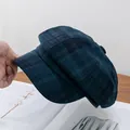 Detailansicht der dunkelblau-grün karierten Schiebermütze mit Wolltextur-Struktur - Verstellbar / Grün