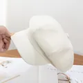 Detalle de la gorra baker boy crema con tela texturizada y botón decorativo superior - Ajustable / Blanco Roto