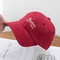 Dettaglio del cotone spazzolato e del ricamo bianco sul berretto da baseball rosso - Regolabile / Borgogna