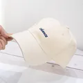 Primer plano detallado de gorra de béisbol de algodón beige con bordado azul - Beige
