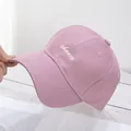 Detalle del bordado 'chance' en la tela de algodón lila claro de la gorra béisbol - Rosa