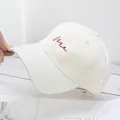 Dettaglio cappellino bianco in cotone con ricamo Me rosso e visiera curva - Taglia Standard / Bianco Sporco