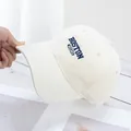 Close-up of Boston 1630 embroidery on a cream cotton twill baseball cap with curved brim - Off White