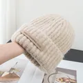 Close-up of beige ribbed knit beanie featuring thick texture and branded woven label - Stretchy / Dark Apricot