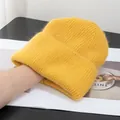 Dettaglio del berretto in maglia giallo brillante con texture morbida e bordo piegato - Giallo zenzero